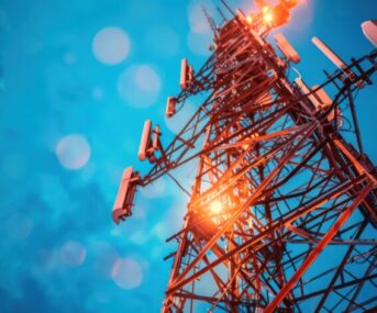 Telecommunications tower transmitting signals, representing the telecommunications industry
